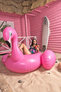 High angle view of girl sitting on pink floor