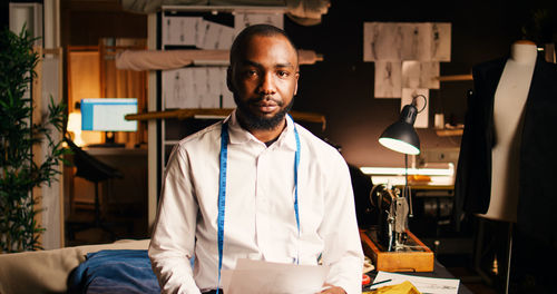 Portrait of young man standing in office