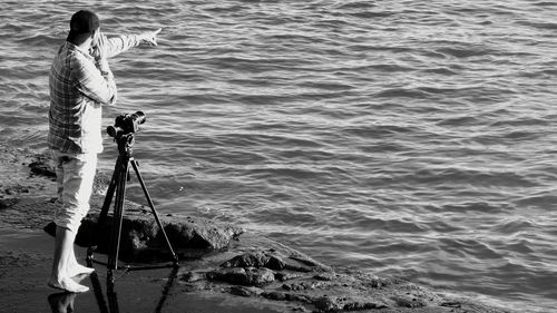 Man photographing at sea shore