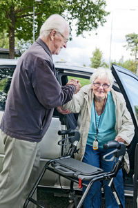 Man helping wife out of car