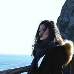 Young woman looking at sea against clear sky