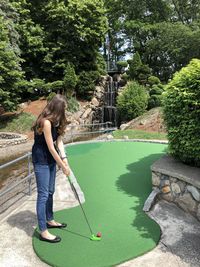 Rear view of woman playing mini golf