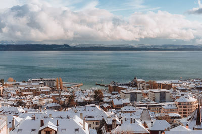Snowy rooftops in neuchâtel with a view on the lake.