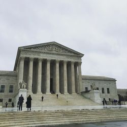 People at supreme court against sky