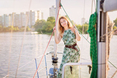 Beautiful woman relaxing on the nose of the yacht at a sunny summer day