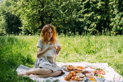 Portrait of young woman sitting on field