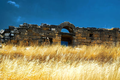 Old building on field against sky