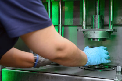 Midsection of man working on machinery