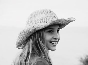 Portrait of young woman wearing hat against sky