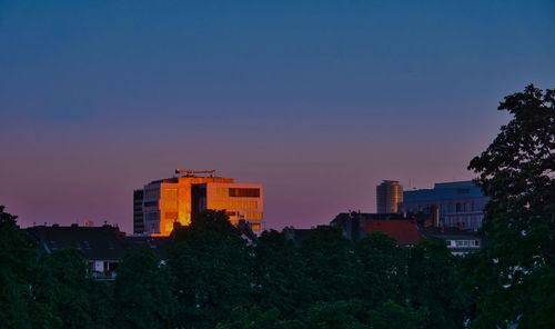 Buildings against clear sky at sunset