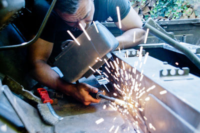 Low angle view of man working on metal