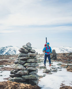 Rear view of person standing on snow against sky