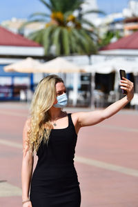 Man photographing with mobile phone standing outdoors