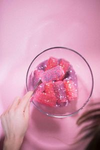 Hand holding glass of pink fruit