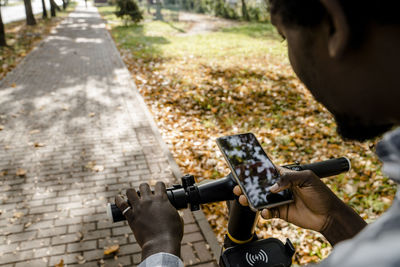 Man with push scooter using app on smart phone