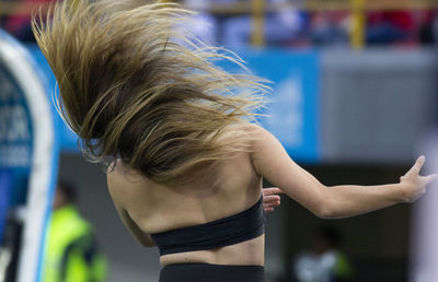 Rear view of young woman dancing outdoors