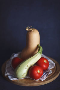 Close-up of fruits in bowl on table against black background