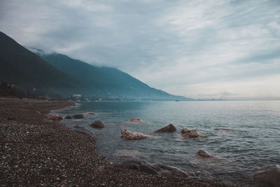 Scenic view of sea and mountains against sky