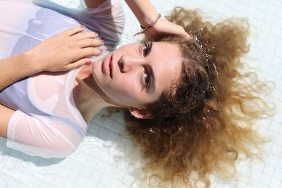 Young woman lying on swimming pool