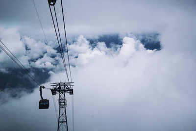 Overhead cable car against cloudy sky