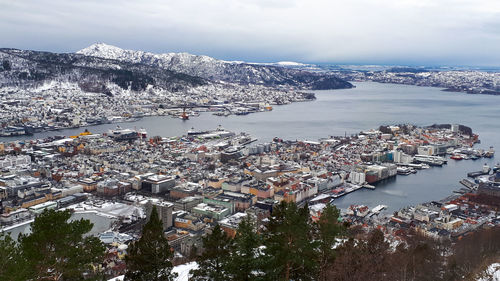 High angle view of city by sea against sky