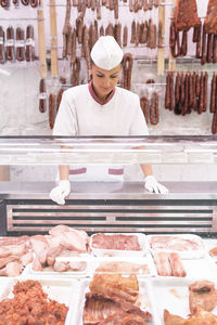 Woman working in meat shop