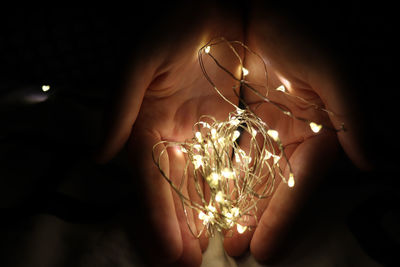 Close-up of hand holding illuminated lights