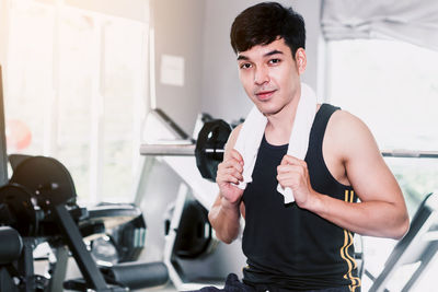 Portrait of young man sitting in gym