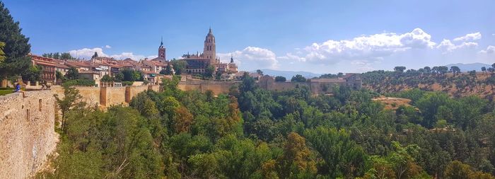 Panoramic view of trees and buildings against sky