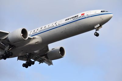 Low angle view of airplane against clear blue sky