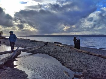 People standing on beach against sky