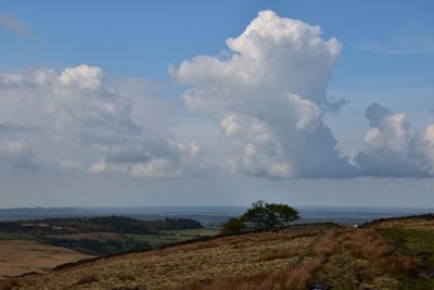 Scenic view from moorland hills over countryside below with sky and clouds