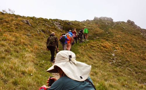 Rear view of people walking on mountain road