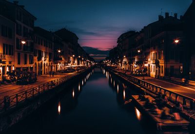 Reflection of illuminated buildings in canal at night 