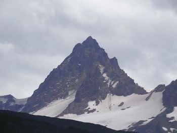 Scenic view of snowcapped mountain against cloudy sky