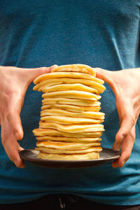 Midsection of man holding pancakes