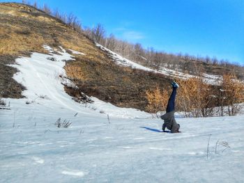 Man on snow field against clear blue sky