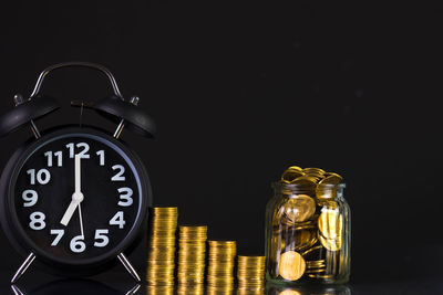 Close-up of clock on table against black background