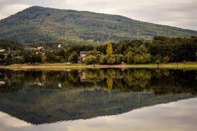 Scenic view of lake by mountains against sky