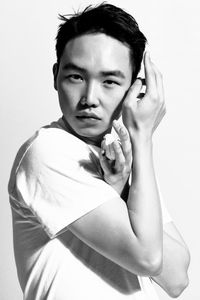 Portrait of young man standing by white background