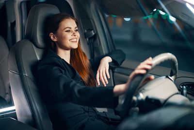 Smiling woman driving car