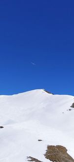 Scenic view of snowcapped mountains against clear blue sky