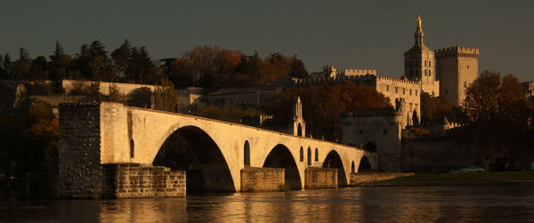 Arch bridge over river against buildings