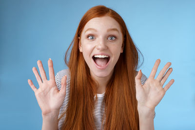 Shocked young woman against blue background