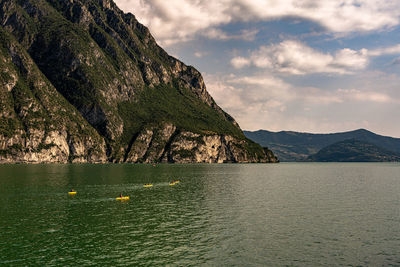 Scenic view of sea by mountains against sky