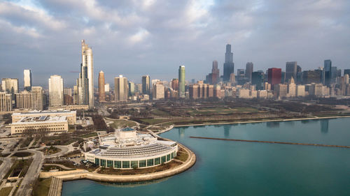 Aerial view of buildings in city against cloudy sky