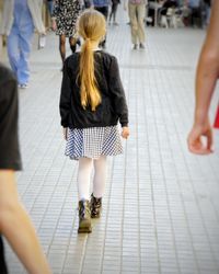 Rear view of women walking on footpath