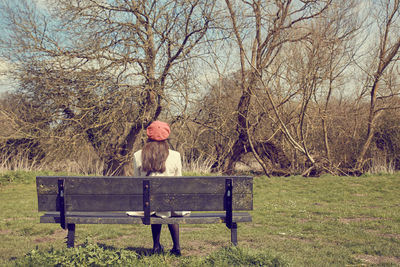 Portrait of man sitting on bare tree