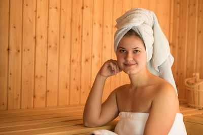 Beautiful young woman relaxing in sauna