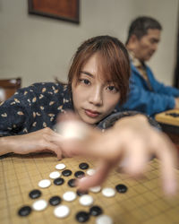 Woman playing with checkers at home